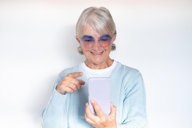 Concetto di videochiamata La donna anziana attraente utilizza lo smartphone per la comunicazione online tramite video