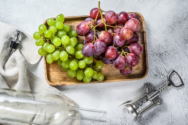 Concetto di vinificazione artigianale. Uva verde e rossa. Sfondo di vino.