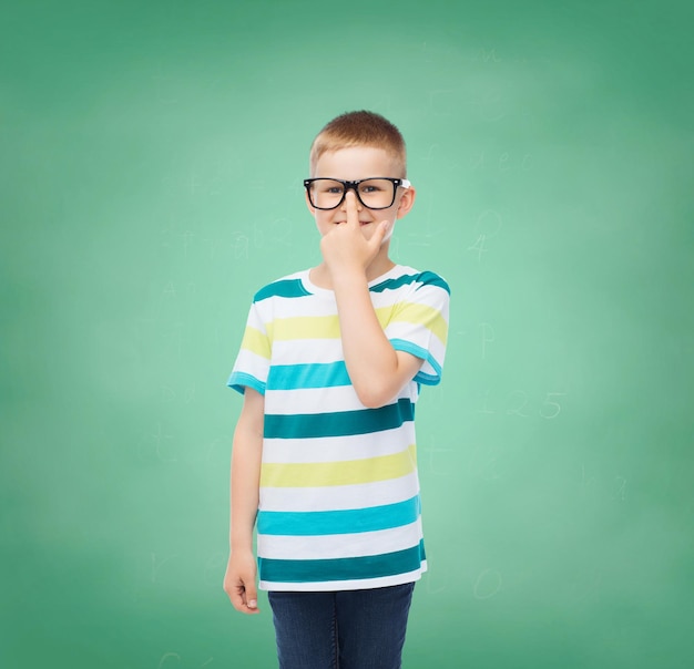 concetto di visione, educazione, infanzia e scuola - ragazzino sorridente con gli occhiali su sfondo verde