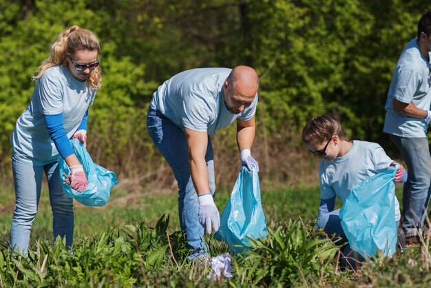 concetto di volontariato, beneficenza, pulizia, persone ed ecologia - gruppo di volontari felici con l'area di pulizia dei sacchi della spazzatura nel parco