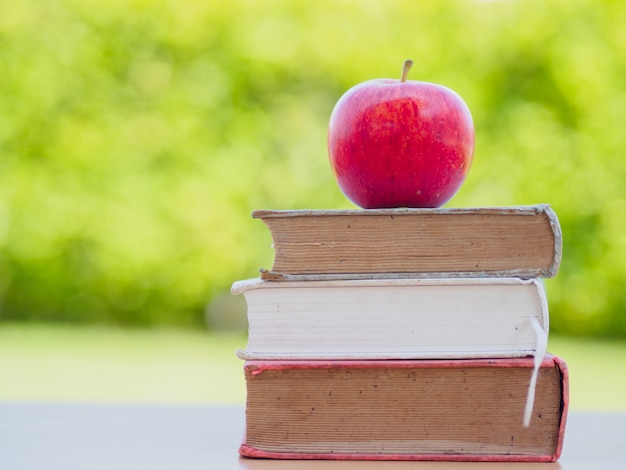 Concetto di World Book Day. La mela rossa ha messo sopra la pila di vecchi libri