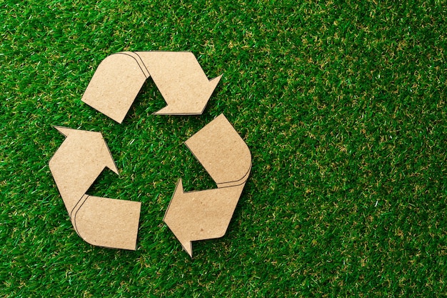 Concetto ecologico di riciclaggio con cartello di riciclo in cartone