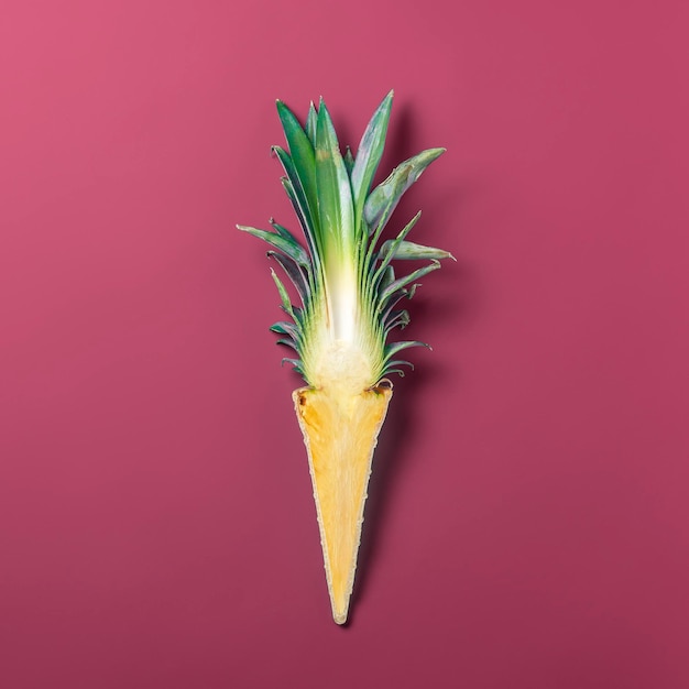 Concetto estivo creativo Tagliare l'ananas in un cono di cialda su sfondo rosso