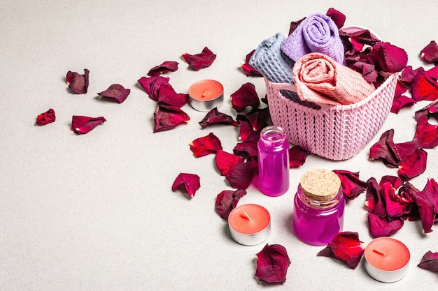 Concetto floreale e spa con petali di rose essiccate, candele profumate e asciugamano morbido