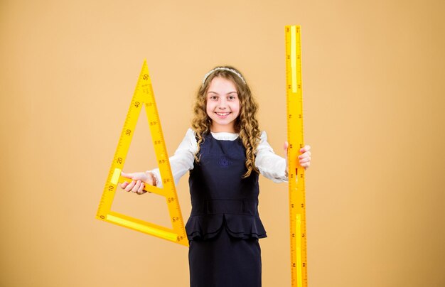 Concetto intelligente e intelligente Dimensionamento e misurazione Geometria di studio degli studenti della scuola Uniforme scolastica per bambini con righello Allievo ragazza carina con grande righello Geometria materia scolastica Concetto di istruzione e scuola