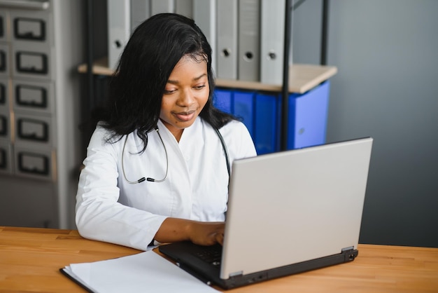 Concetto medico e tecnologico sanitario medico femminile africano con laptop