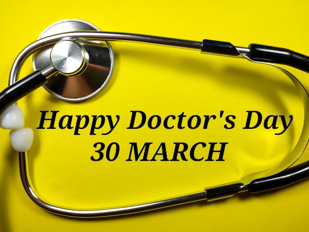 Concetto medicoTesto Happy doctor's day 30 marzo con stetoscopio su sfondo giallo