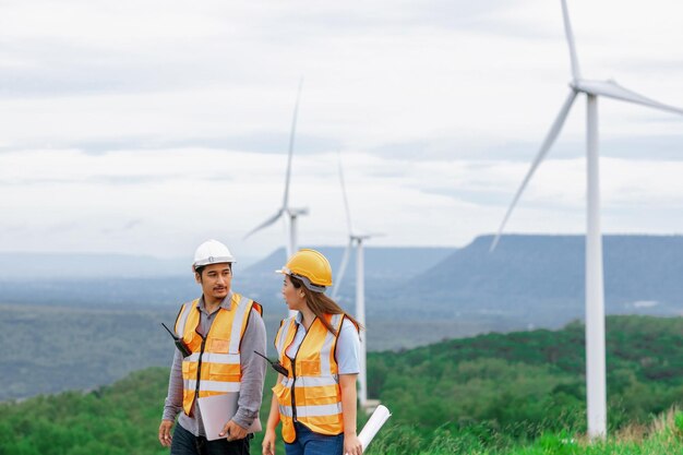 Concetto progressivo di ingegneri che lavorano nel parco eolico in cima alla montagna