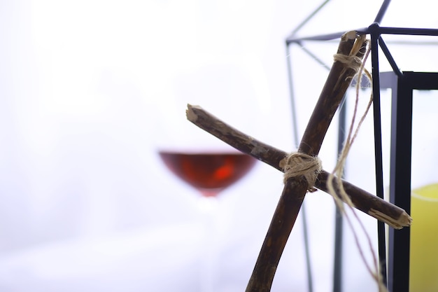 concetto religioso. Croce di legno fatta a mano su sfondo bianco. Lampada in vetro di vino con candele.