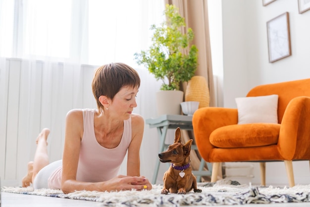 Concetto stile di vita sano Yoga e fitness Donna carina con cane di piccola taglia