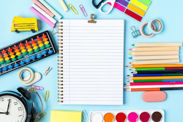 Concetto torna a scuola sveglia colore gesso matita notebook cancelleria su sfondo blu design