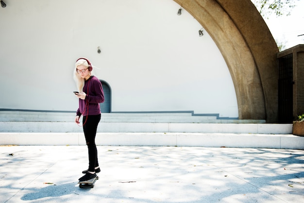 Concetto urbano all&#39;aperto della ragazza Skateboad