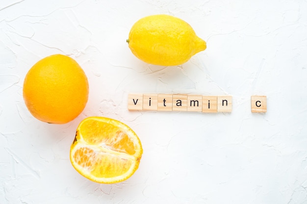 Concetto vitamina c. Limone e arance su sfondo bianco