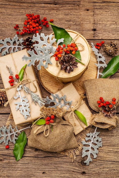 Concetto zero rifiuti di Natale. Imballaggio ecologico di Capodanno. Scatole festive in carta artigianale e sacchi con diverse decorazioni organiche