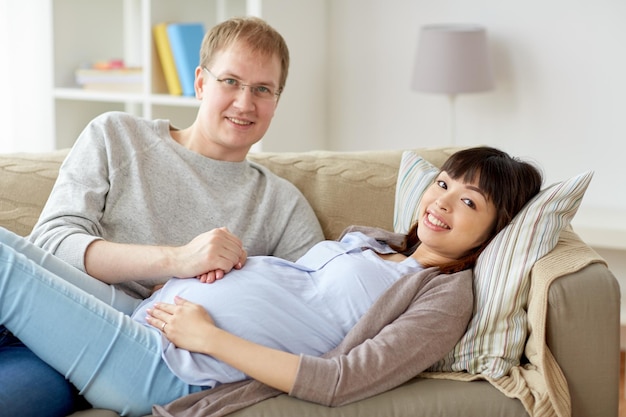 concezione della gravidanza, della famiglia e delle persone - moglie incinta felice con marito a casa