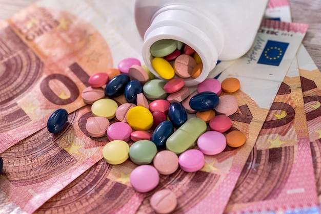 Concezione farmaceutica con farmaci colorati sulle banconote in euro