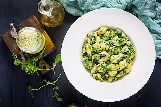 Conchiglie agli spinaci e pesto di piselli. Cucina italiana. Cibo vegano. Vista dall'alto