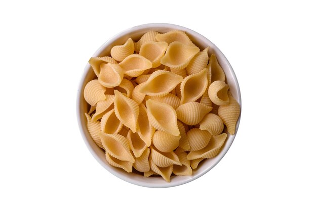 Conchiglie di pasta italiana cruda di grano duro con sale e spezie di verdure