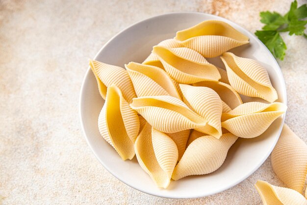 Conchiglie pasta cruda big shell grano duro farina di semola pasto sano spuntino alimentare sul tavolo