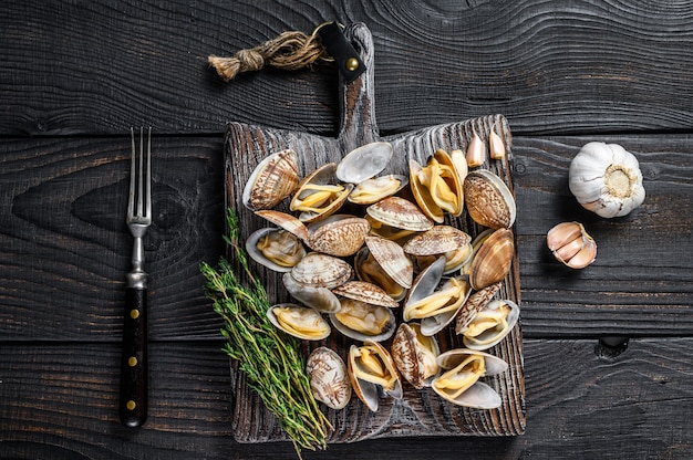 Conchiglie Vongole di vongole su un tagliere di legno