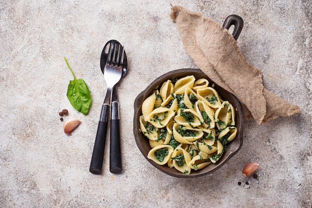 Conchiglioni di pasta con spinaci in salsa cremosa