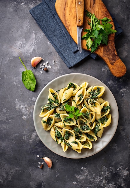 Conchiglioni di pasta con spinaci in salsa cremosa