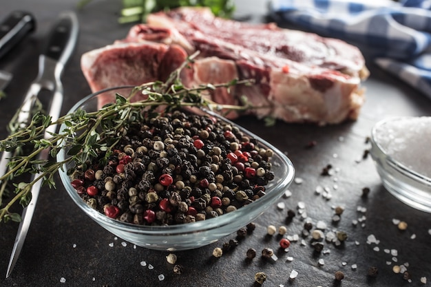 Condimento di quattro tipi di piselli al pepe in una ciotola con carne cruda ed erbe aromatiche.