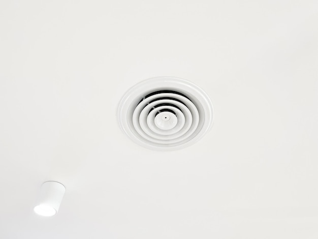 Condizionatore d'aria a cassetta a soffitto e lampada moderna su condizionatore d'aria a condotto a soffitto bianco per la casa o l'ufficio