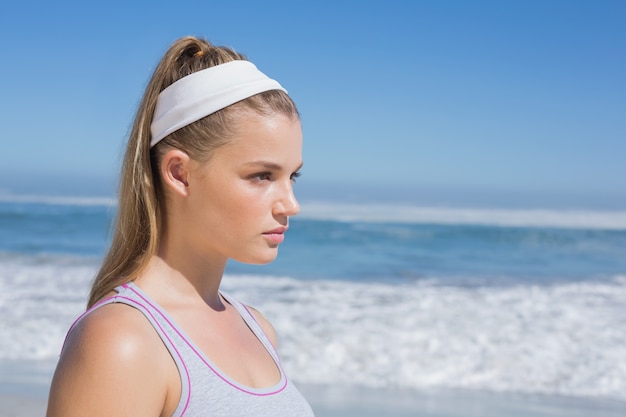 Condizione bionda seria sportiva sulla spiaggia