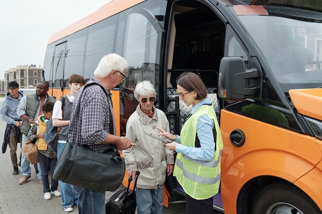 Conduttore di autobus che controlla i biglietti dei passeggeri prima della corsa