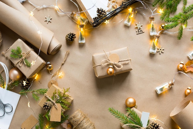 Confeziona un regalo per Natale e Capodanno in materiali ecologici: carta kraft, rami di abete vivo, pigne, spago. Etichette con mock up, decoro naturale, fatte a mano, fai da te. Atmosfera festosa. Sfondo di Natale