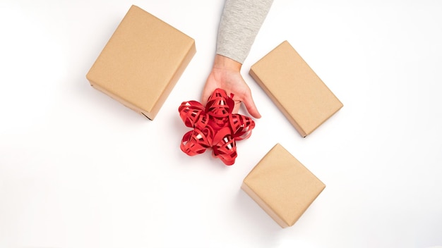 Confezionamento di regali in scatola kraft con un nastro rosso