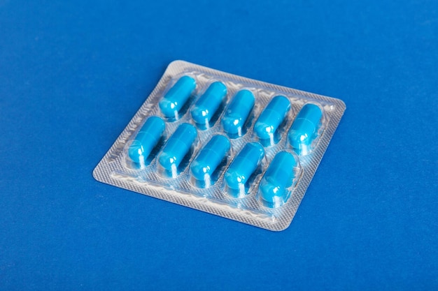Confezione blister con vitamina su sfondo colorato Pillole medicinali su sfondo chiaro Farmaci e pillole da prescrizione medica a sfondo piatto Pillole mediche blu in blister