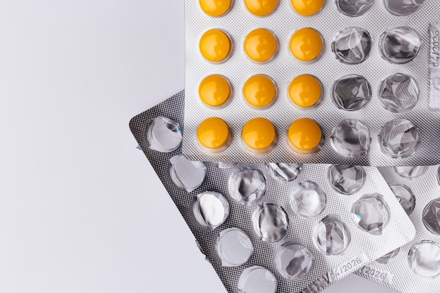 Confezione di plastica vuota di pillole e blister con pillole gialle Concetto di assistenza sanitaria e medicina