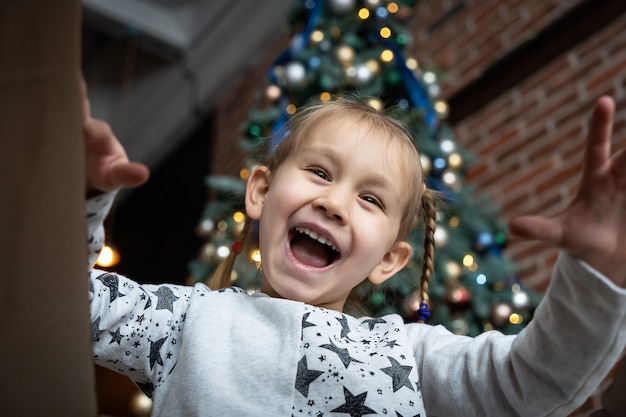 Confezione regalo aperta bambina con gioia e felicità albero di Natale