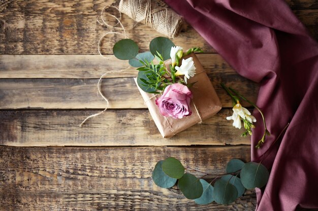 Confezione regalo artigianale con fiori su tavola di legno