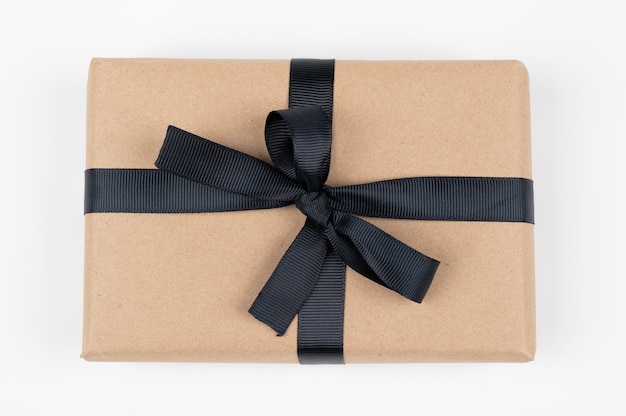 Confezione regalo artigianale su sfondo bianco, decorata con nastro nero. Per compleanni, regali di anniversario, cartoline regalo. Foto di alta qualità