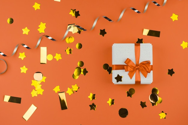Confezione regalo bianca su sfondo arancione festivo Confezione regalo bianca con fiocco arancione