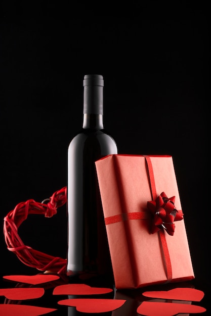 Confezione regalo, bottiglia di vino e cuori rossi