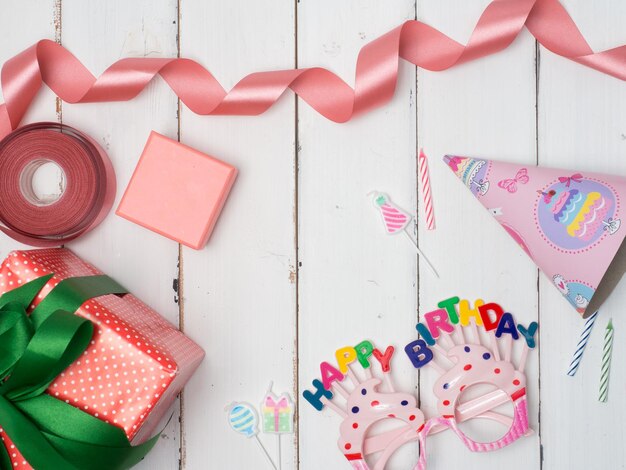 Confezione regalo con articoli per feste colorati su sfondo rosa Cornice piatta per feste con regalo blu bo