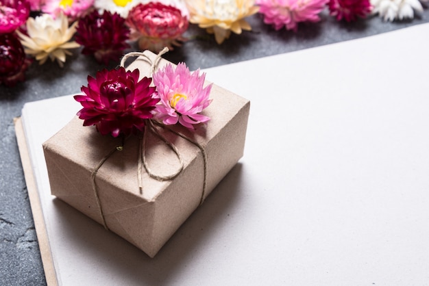 Confezione regalo con decorazioni floreali su fondo di carta