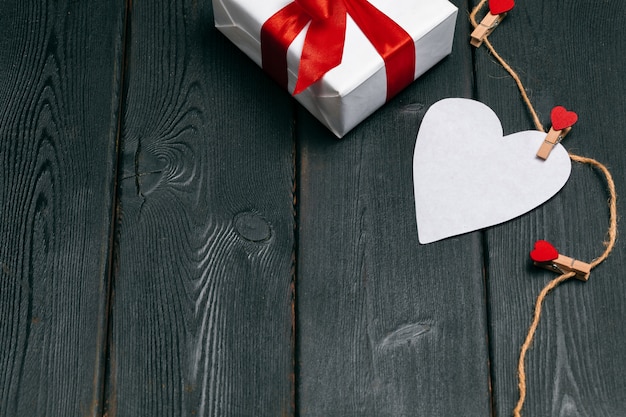 Confezione regalo con fiocco rosso e cuori di carta per San Valentino