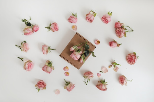 Confezione regalo con fiori di rosa rosa su sfondo bianco