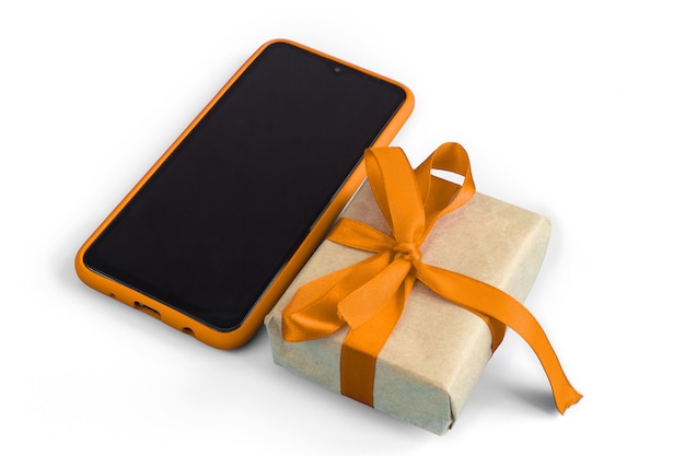 Confezione regalo con nastro adesivo arancione con uno smartphone su sfondo bianco. Vacanze e concetto di vendita.