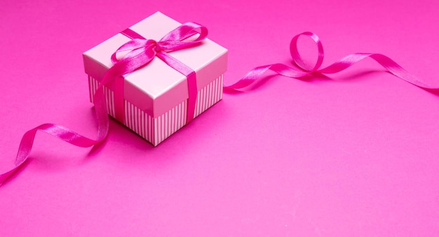 Confezione regalo con nastro su sfondo rosa Concetto regalo di compleanno