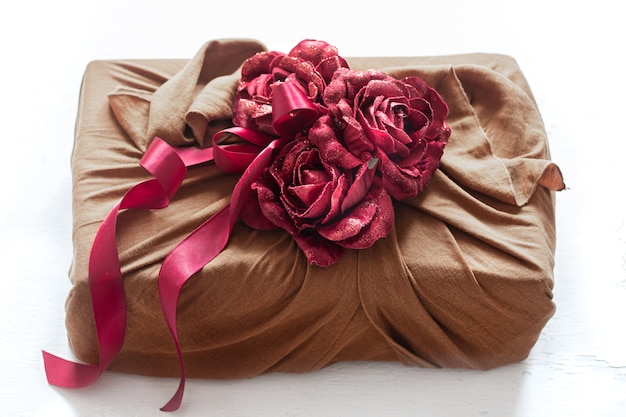 Confezione regalo decorata con nastri e rose decorative su articoli in maglia. Confezione regalo originale per San Valentino.