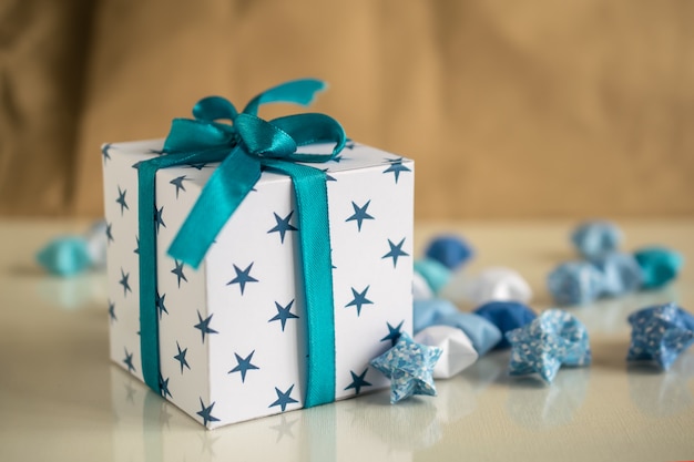 Confezione regalo di buon compleanno con stelle di carta e nastro blu