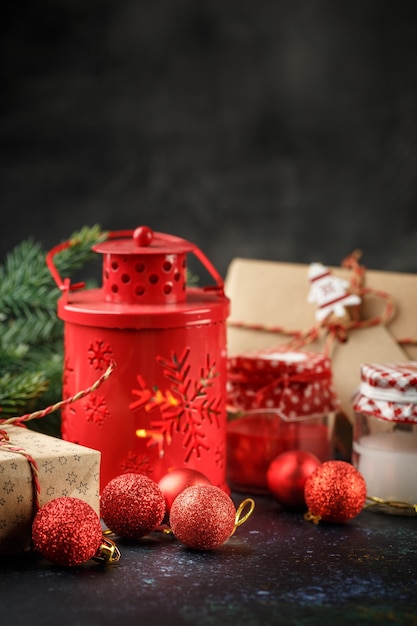 Confezione regalo di Natale, lanterna rossa con candela, palline rosse e luce decorativa