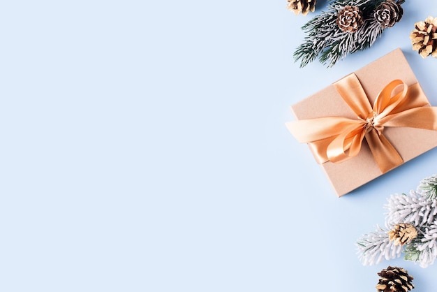 Confezione regalo di Natale piatta su sfondo blu con abete e cono a palla Spazio per la copia dello sfondo del nuovo anno felice