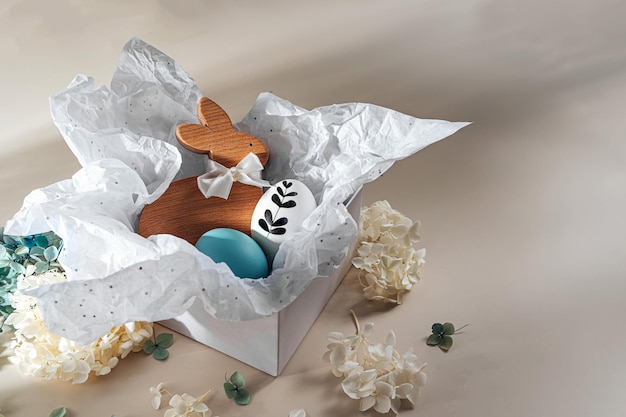 Confezione regalo di Pasqua Coniglietto di Pasqua e uova di Pasqua con carta bianca in scatola con fiori Buon concetto di Pasqua